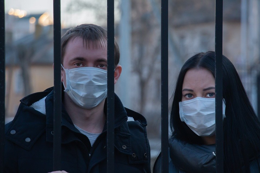 Couple Behind Railings In Face Masks
